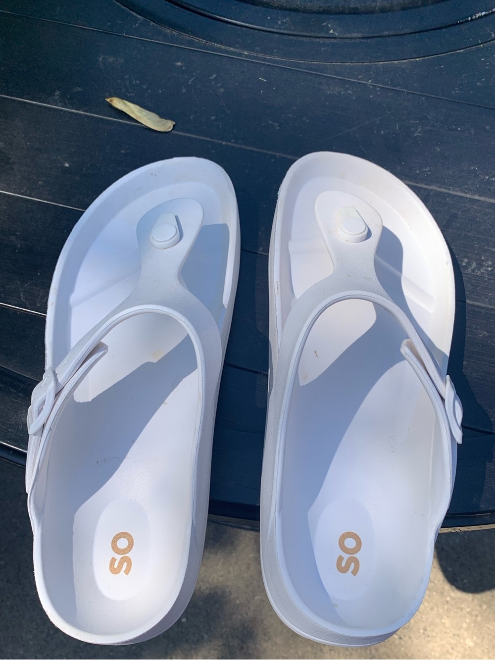 White platform thong sandals with cushioned footbed. Gold SO logo